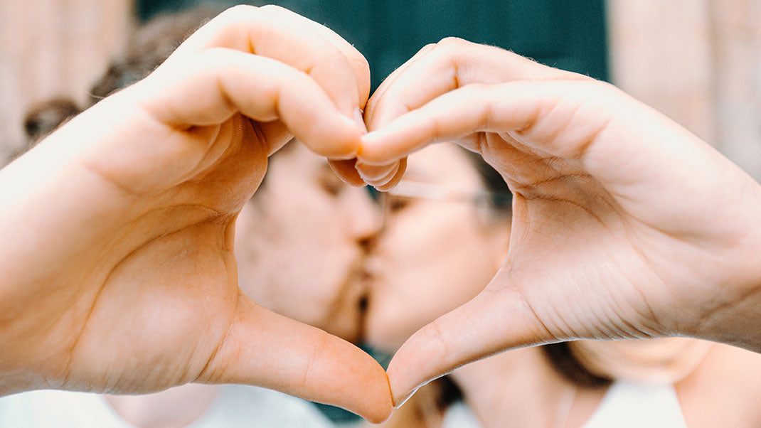 hands-meet-to-form-a-heart-and-frame-kissing-couple