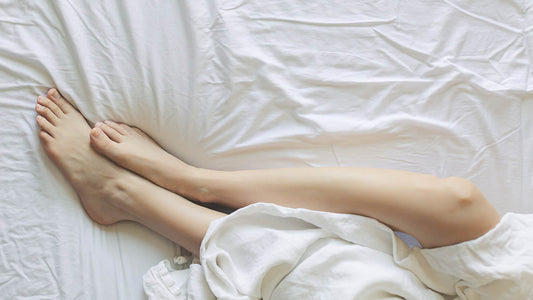 woman's legs come out the blanket in the bed